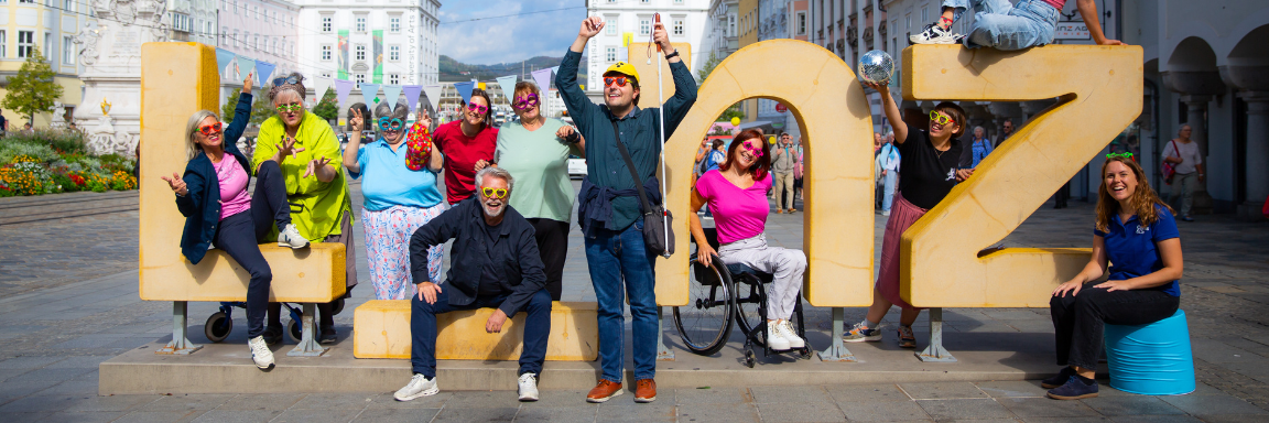 Menschen beim Linz Schriftzug