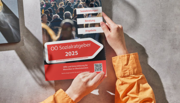 Man sieht Arme, die einen oö Sozialratgeber halten