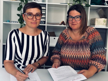 Auf dem Bild sieht man Magdalena Danner und Michael Haunold, die die Stellungnahme zur Sozialhilfe-Novelle unterschreiben