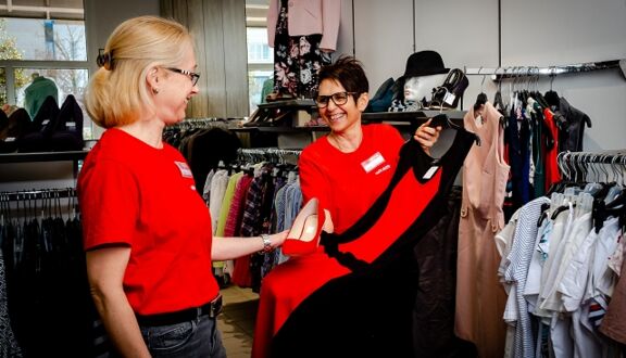 Verkäuferin berät Kundin in einem Bekleidungsgeschäft