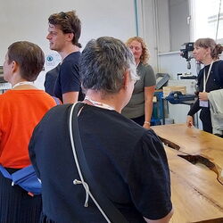 In einer Holzwerkstatt sprechen Menschen miteinander