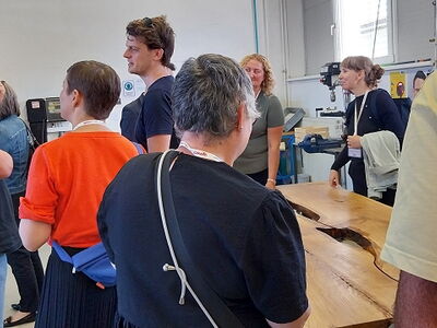 In einer Holzwerkstatt sprechen Menschen miteinander