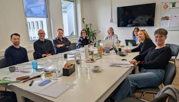 Vorstandsmitglieder sitzen an großem Besprechungstisch